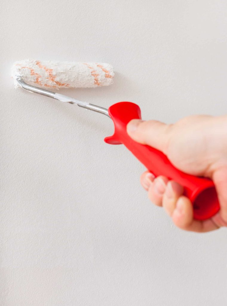 renovation of apartment - painter paints wall with paint roller